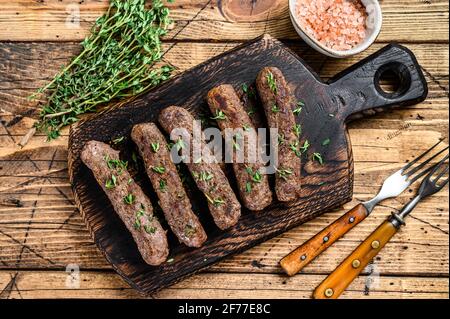 Homamade gegrillte Lula Kebab Fleischwürste auf einem Schneidebrett. Holzhintergrund. Draufsicht Stockfoto