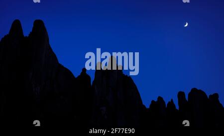 Der Halbmond hinter der Silhouette des Montserrat steht zur blauen Stunde (Provinz Barcelona, Katalonien, Spanien) ESP: Luna creciente detrás de Montserrat Stockfoto