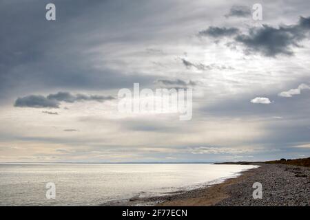 Der Strand von Arbroath an einem bewölkten Tag, die Wolke dünn genug, um das Sonnenlicht zu ermöglichen, indem sie ein eher ätherisches Licht im Bild erzeugt. Stockfoto
