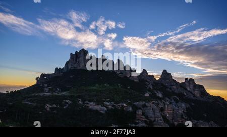 Montserrat-Westwand und Roca Foradada von Sant Pau Vell de la Guàrdia bei Sonnenaufgang gesehen (Provinz Barcelona, Katalonien, Spanien) Stockfoto