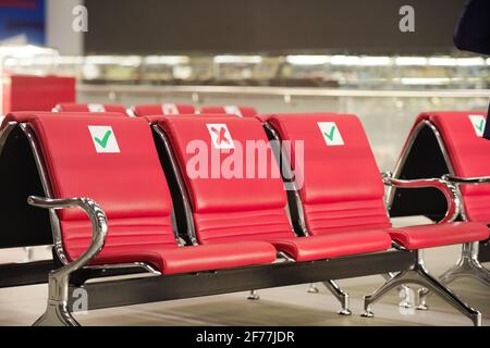 Mehrere Reihen leerer roter Ledersitze in der Lounge des modernen Flughafens, wo Sie sitzen, entspannen oder ein Nickerchen machen können, während Sie auf den Flug warten Stockfoto