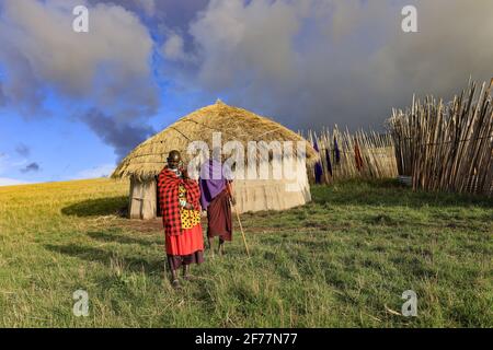Tansania, Ngorongoro, Arusha-Region, Boma Mokila, Ngorongoro-Schutzgebiet, Ein paar Massai-Hirten mit einem Baby, am Ende des Tages im Boma Stockfoto