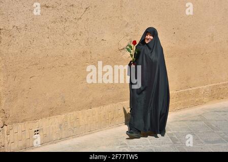 Iran, Yazd, von der UNESCO zum Weltkulturerbe erklärt, Alte Dame mit Rose Stockfoto
