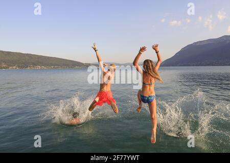 Frankreich, Haute Savoie, Saint Jorioz, Lake Annecy, die Familie springt am frühen Morgen am Strand von Saint Jorioz ins Wasser Stockfoto