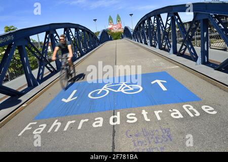 Deutschland, Baden Württemberg, Freiburg im Breisgau, Radfahrer auf der blauen Brücke (Wiwili-Brücke) und der Herz Jesu kirche Stockfoto