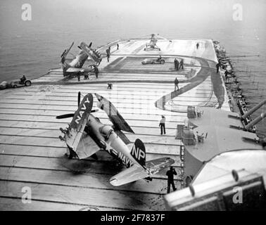 Die Besatzungsmacht der USS Valley Forge (CV-45) nutzt während der Einsätze vor Korea, etwa Anfang 1951, Flugtraktoren mit Strombsen, um Schnee vom Flugdeck des Frachtführers zu fegen. Das Foto stammt vom 8. Mai 1951, aber Valley Forge beendete ihren zweiten Einsatz im Koreakrieg Ende März dieses Jahres. Im Vordergrund steht ein F4U-4 Corsair Fighter. Die auf dem Vorwärtsflugdeck sind ein AD Skyraider-Angriffsflugzeug und ein HO3S-Hubschrauber Stockfoto