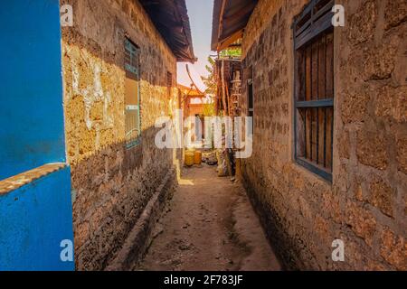 Schmale Gasse zwischen typischen Steinhäusern in einem afrikanischen Dorf auf der Insel Wasini. Es ist ein kleiner Weiler in Kenia. Stockfoto