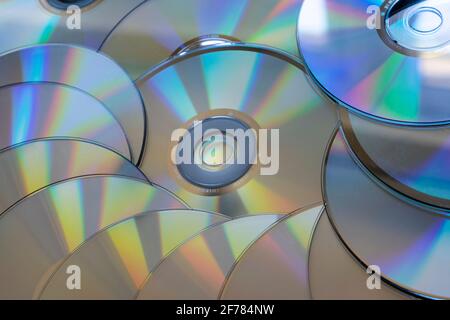 Ein Stapel von mehreren CDs (Compact Discs) mit der silbernen Seite nach oben (von unten nach oben/auf dem Kopf). CDs sind ein digitales Datenspeicherformat für optische Discs Stockfoto
