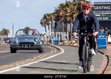 1962 Chevrolet Corvette C1 Oldtimer fährt in Southend on Sea, Essex, Großbritannien, mit Radfahrern auf der Fahrradspur und Palmen. WESTERN Esplanade Road Stockfoto