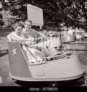 FÜNFZIGER JAHRE TEENAGER-PAAR IM VERGNÜGUNGSPARK REITEN IN DER PEITSCHE BLICK IN DIE KAMERA - P5201 HAR001 HARS ALBERNEN JUGENDSTIL COMIC RIDE STARKE FREUDE LIFESTYLE GESCHWINDIGKEIT FRAUEN KOPIEREN RAUM HALBLANGE PERSONEN FÜRSORGLICH MÄNNER TEENAGER MÄDCHEN TEENAGER JUNGE UNTERHALTUNG S & W AUGENKONTAKT DATING AMÜSANT HUMORVOLLES GLÜCK NERVENKITZEL FRÖHLICHE AUFREGUNG CREW SCHNITT KOMISCHE ATTRAKTION LÄCHELT VERBINDUNG BALZ KOMÖDIE FRÖHLICH STILVOLL TEENAGER PEITSCHE PERSÖNLICHE BINDUNG MÖGLICHKEIT ZUNEIGUNG EMOTION JUGENDLICHE SOZIALE AKTIVITÄT ZWEISAMKEIT SCHWARZ UND WEISS BEILÄUFIGE KAUKASISCHE ETHNIE UMWERBEN HAR001 ALTMODISCH Stockfoto