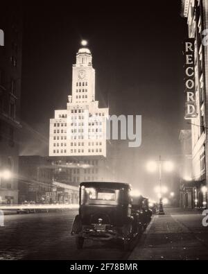 1930ER NORTH BROAD STREET NACHT BELEUCHTET ELVERSON GEBÄUDE HEIMAT VON THE INQUIRER & NEON FÜR DAS PLATTENGEBÄUDE PHILADELPHIA PA USA - Q74160 CPC001 HARS AUTOS AUSSENANSICHT NIEDERWINKEL PA BREITE IMMOBILIEN COMMONWEALTH BREITE STRASSE STRUKTUREN AUTOMOBILE STÄDTE VIERTE ESTATE KEYSTONE STATE FAHRZEUGE GEBÄUDE STRASSENLAMPEN NACHT SCHWARZ UND WEISSE STADT DER BRÜDERLICHEN LIEBE LATERNENPFOSTEN BELEUCHTET ALTMODISCH Stockfoto