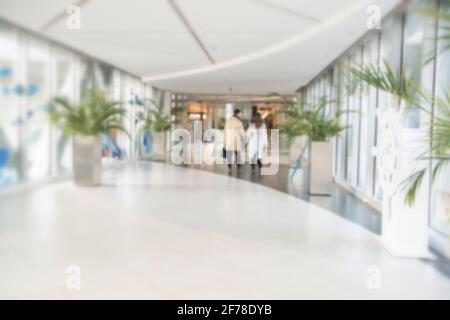 Abstrakt verwischen Shopping Mall Korridor. Verschwommenes Interieur im Kaufhaus im Einzelhandel und in der Halle. Hintergrund oder Hintergrund des defokussischen Bokeh-Effekts für das Geschäftskonzept. Hochwertige Fotos Stockfoto