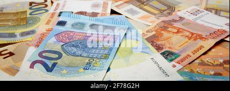 Große Anzahl von Banknoten von unterschiedlichem Wert des Euro Und russische Rubel Stockfoto