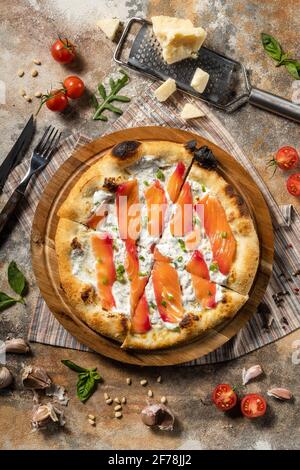 Italienische Pizza mit Lachs auf einem Holzbrett. Stockfoto