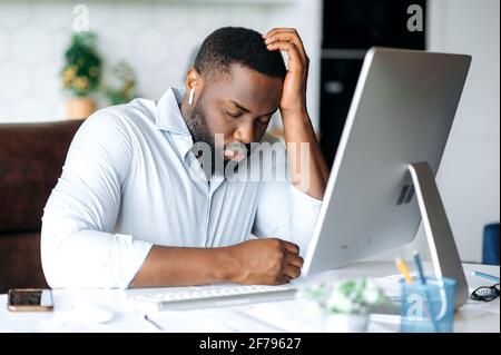 Schlafende Mitarbeiterin. Gutaussehender müde, müde, müde afroamerikanische bärtige männliche Manager, Makler oder Freiberufler, in formeller Kleidung, zu Hause am Computer arbeitend, machte eine Pause, schloss seine Augen, brauchte Ruhe Stockfoto