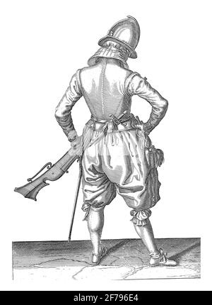 Ein Soldat, voller Länge, von hinten gesehen, der mit seiner linken Hand ein Ruder (eine bestimmte Art von Schusswaffe) an seinem linken Oberschenkel hält und auf die Stange zeigt Stockfoto