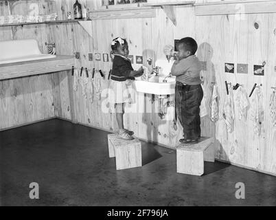 Kinder von Landarbeitern waschen sich vor einem heißen Mittagessen in der Kindertagesstätte im Okeechobee-Migrationsarbeitslager ab. Belle Glade, Florida, USA, Marion Post Wolcott, U.S. Farm Security Administration, Februar 1941 Stockfoto