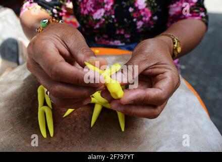 Balinesin bereitet eine handgemachte Opfergabe namens Jajan Suci oder Palegembai in einem Hindu-Tempel in Bali, Indonesien, vor. Stockfoto