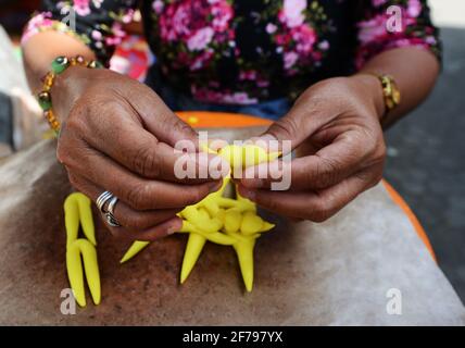 Balinesin bereitet eine handgemachte Opfergabe namens Jajan Suci oder Palegembai in einem Hindu-Tempel in Bali, Indonesien, vor. Stockfoto