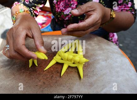 Balinesin bereitet eine handgemachte Opfergabe namens Jajan Suci oder Palegembai in einem Hindu-Tempel in Bali, Indonesien, vor. Stockfoto