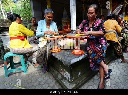 Balinesin bereitet eine handgemachte Opfergabe namens Jajan Suci oder Palegembai in einem Hindu-Tempel in Bali, Indonesien, vor. Stockfoto