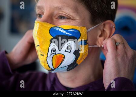 Cuxhaven, Deutschland. März 2021. Birgits Berends zieht ihre Pinguin-Maske an. Pinguine wo immer Sie hinschauen: Ob als Plüschtiere, Sammlerfiguren oder an Krawatten - das Cuxhaven Penguin Museum wimmelt von Fracken. Quelle: Sina Schuldt/dpa/Alamy Live News Stockfoto