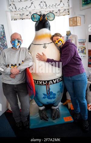 Cuxhaven, Deutschland. März 2021. Birgits Berends (r) und Stefan Kirchhoff stehen neben einer großen Pinguinfigur im Museum. Pinguine, wo das Auge sieht: Ob als Plüschtiere, Sammlerfiguren oder an Krawatten - das Cuxhaven Penguin Museum wimmelt von Fracken. Birgits Berends und Stefan Kirchhoff streben mit ihrer Sammlung ein fünftes Album an. Quelle: Sina Schuldt/dpa/Alamy Live News Stockfoto