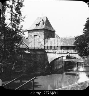 SkiopT-Ikone mit Motiven einer überdachten Brücke in der Stadtmauer, Nürnberg. Das Bild wurde in Karton mit der Aufschrift The Journey 1910 gespeichert. Nürnberg 10. XVIII Stockfoto