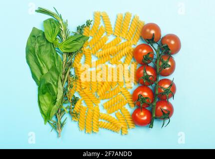 Rohe Fusilli-Pasta mit Tomaten, Kräutern und Basilikum. Italienische Pasta mit Zutaten in den Farben der italienischen Flagge. Hochwertige Fotos Stockfoto