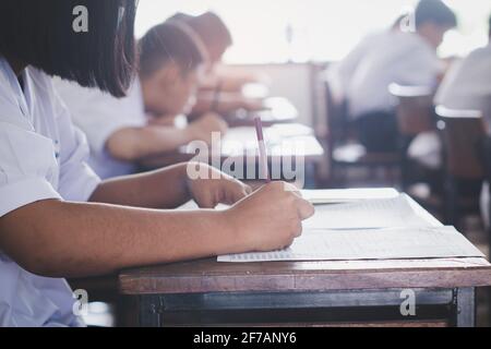 Schüler, die die Prüfung ablegen und Antworten im Klassenzimmer mit Stress schreiben. Testkonzept für den Bildungsbereich Stockfoto