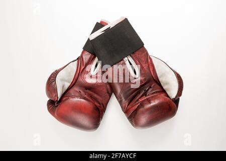 Ein Paar Boxhandschuhe aus kastanienbraunem Leder auf weißem Stoff Hintergrund, wobei die Handflächen nach oben zur Kamera zeigen Eine Ansicht von oben auf weißem Hintergrund Stockfoto