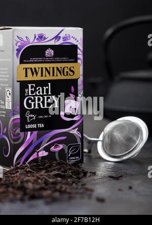 LONDON, Großbritannien - 21. OKTOBER 2020: Box mit Twinings Earl Grey loser Tee mit eiserner Teekannen und Sieb-Infuser auf schwarzem Hintergrund. Stockfoto