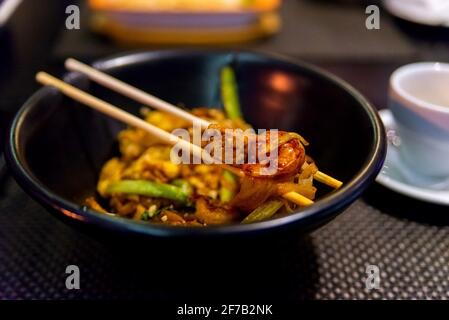 Thai Food-Stir gebraten Noodle, Pad Thai in dunklen Teller mit Sticks. Stockfoto