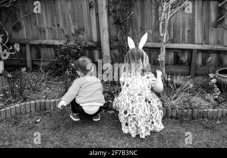 Ostern 2021 mit der Familie 2 kleine Kinder Bruder und Schwester Spielen in einem Garten Stockfoto