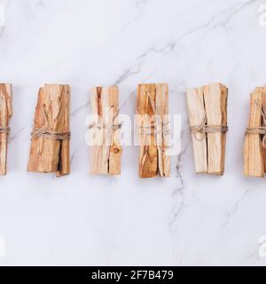 Quadratische Komposition mit Palo Santo Baumstäben auf Marmorhintergrund - heiliger Weihrauchbaum aus Lateinamerika. Meditation, geistige Gesundheit und persönlich Stockfoto