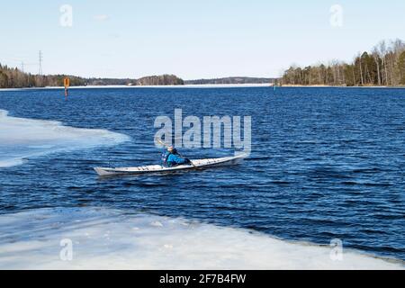 Kajakfahrer auf eisigen See, Finnland Stockfoto
