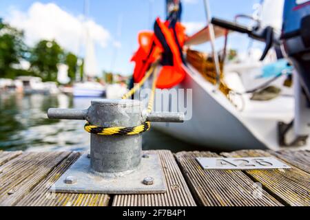 yacht mit einer Linie gebunden um eine Befestigung am Kai festgemacht, Anlegestelle an einem Pier Nahaufnahme Ansicht Stockfoto