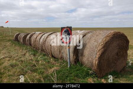 Runde Heuballen, die in Garn eingewickelt sind, am Rand einer Flugfeld-Grasbahn auf den Chalklands der Salisbury Plain Wilts UK Stockfoto