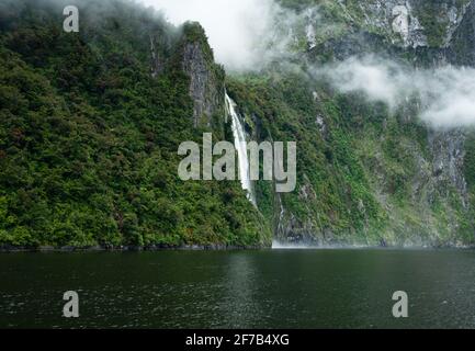 Stirling Falls mit blühendem Southern Rata Forest, Milford Sound, Neuseeland Stockfoto