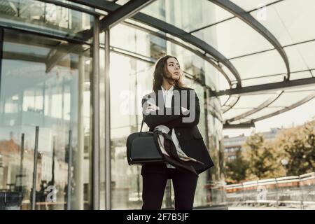 Geschäftsfrau, die vor dem Bürogebäude steht Stockfoto