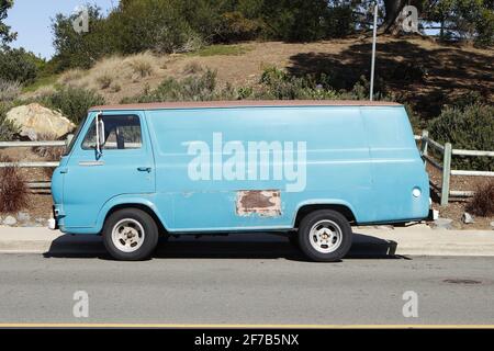 Old Blue Van parkte auf der Straße mit Rostfleck Stockfoto