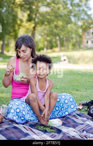 Mädchen sitzen auf Mutters Schoß Stockfoto