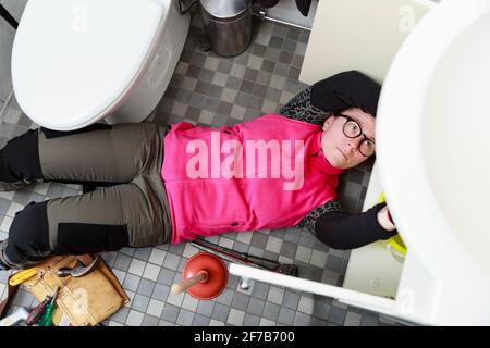 Weibliche Klempner Reparatur Badezimmer Waschbecken Stockfoto