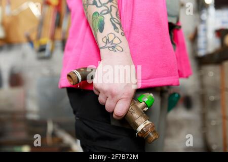 Klempnerhände halten Rohr Stockfoto