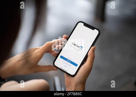 CHIANG MAI, THAILAND, APR 05, 2021 : EINE Frau hält Apple iPhone mit LinkedIn-Anwendung auf dem Bildschirm.LinkedIn ist eine Foto-Sharing-App für Stockfoto