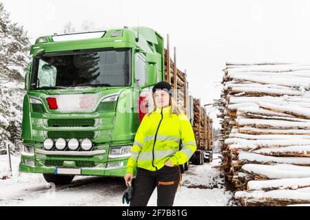 Lächelnde Frau, die vor einem Lastwagen steht Stockfoto