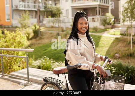 Lächelnde Frau mit Fahrrad Stockfoto