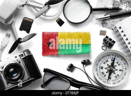 Flagge von Guinea Bissau und Reisezubehör auf weißem Hintergrund. Stockfoto