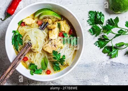 Thailändische grüne Hühnersuppe mit Nudeln, Chili und Kraut in weißer Schüssel, Draufsicht. Stockfoto