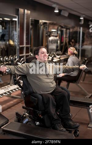 Mann im Rollstuhl trainiert im Fitnessstudio Stockfoto